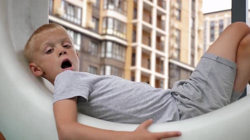 Boy Lying on Structure at Urban Playground