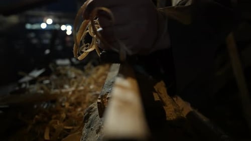 Carpenter Smoothing Wooden Plank as Shavings Curl in Rustic Workshop Crafting Traditional Antique Fu