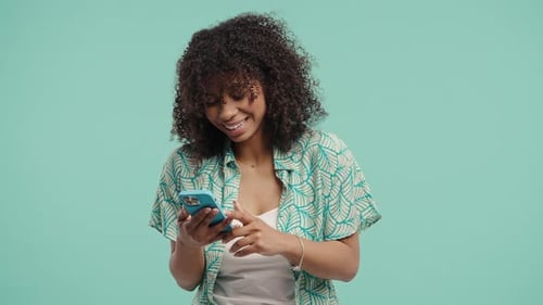 Smiling Woman Interacting with Smartphone on Light Blue Background