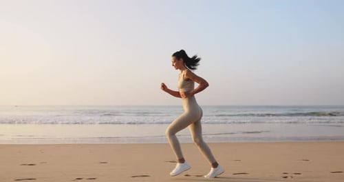 Female Runner Jogging During Outdoor Workout on the Beach in Slow Motion