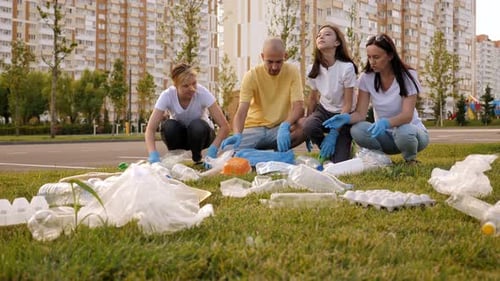 Group Collecting Trash and Plastic Bottles in Park