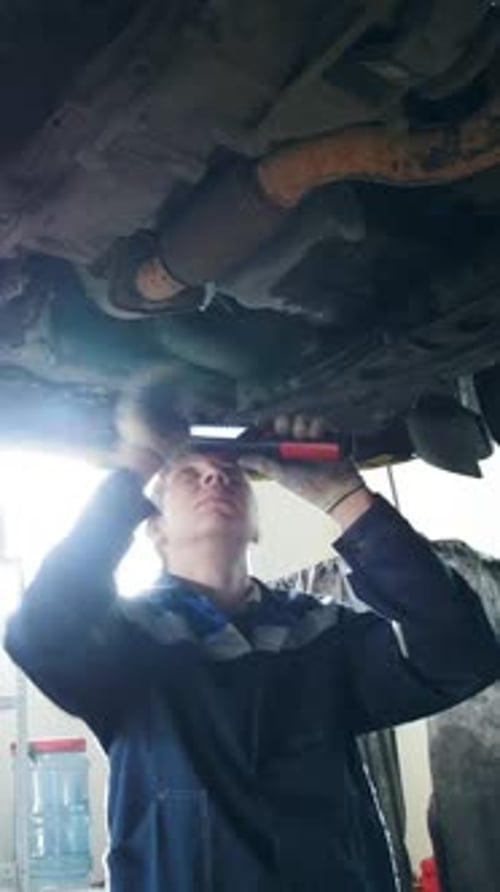 Car Lifted in Automobile Service Garage for Repairing Sunny Rays Backlight Slider Shot