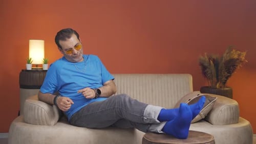 Man Lounging in Blue Socks and Yellow Glasses