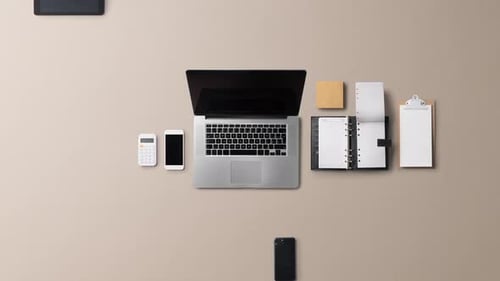 Office desktop workspace flat lay top view with laptop and supplies on gray