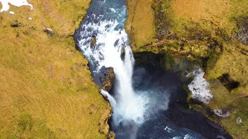 aerial view over the gigantic kvernufoss waterfall in southern iceland. the blue river is surrounded