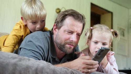 Father and Children Enjoying Smartphone Together at Home