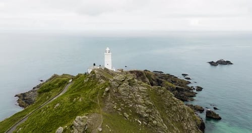 Drone Flying Out To Sea Over Lighthouse On Spectacular Rocky Coast