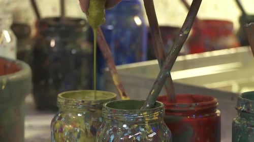 Paint Jars With Paintbrushes in Art Studio