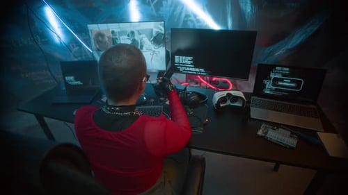 Female Coder Working at Desk With Multiple Computers