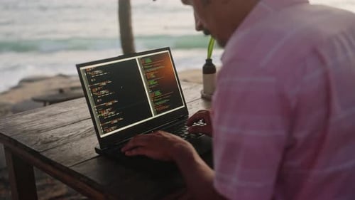 Un développeur Web travaille sur un ordinateur portable dans un café en bord de mer en programmant avec vue sur la mer au coucher du soleil Coder Types Code