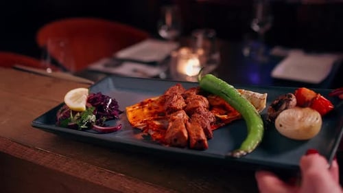 Delicious Kebab Plate in Dimly Lit Restaurant Setting