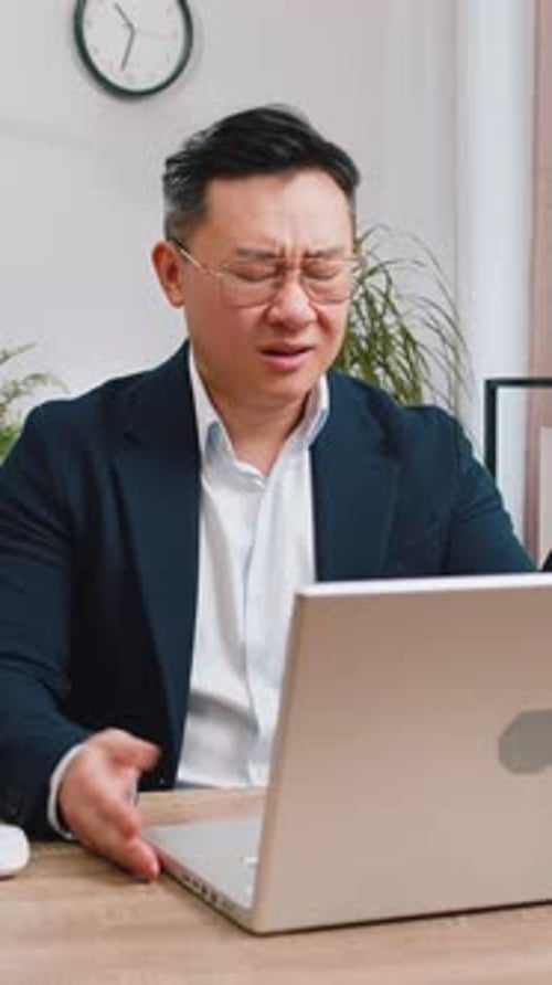 Upset Man Closing Laptop in Office