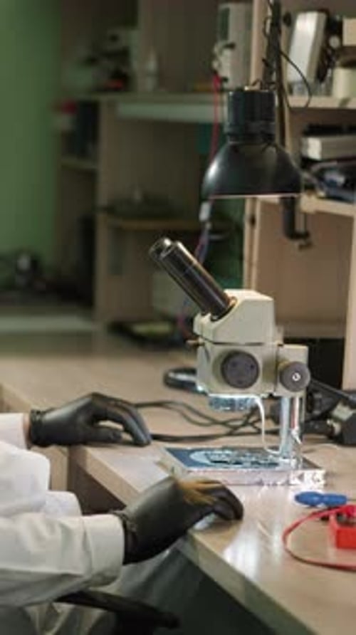 Scientist Uses Microscope in Vertical Lab Setting
