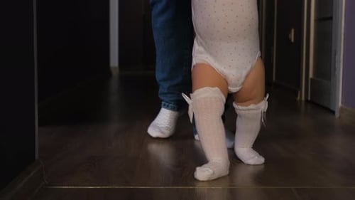 Baby Taking First Steps with Assistance
