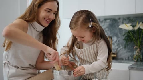 Mother and Daughter Baking Together in Kitchen
