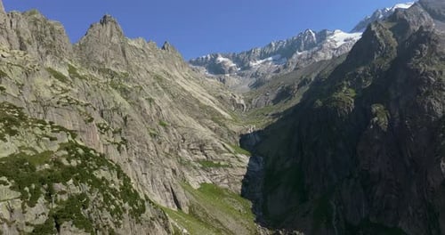 Aerial shot of steep granite cliffs and alpine peaks in the Bernese Alps, Switzerland, under a