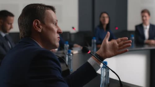 Speech Of Political Speaker At Meeting Room Of Modern Business Center. Adult Man In Suit Explains...
