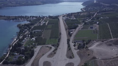 4K-Luftbild, 100-Grad-Drehwinkel, mit Blick auf Cottages, Land, Strand und Häuser, die parallel über den Seeufer fliegen