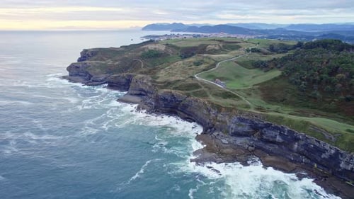 Drone capture the aerial view of the green Isla island and blue Cantabrian sea from a great height