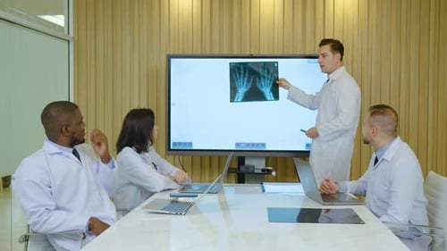 Medical Professionals Discussing X-Ray Scan in Meeting