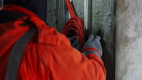 Techniker befestigt Netzwerkkabel mit Kabelbindern