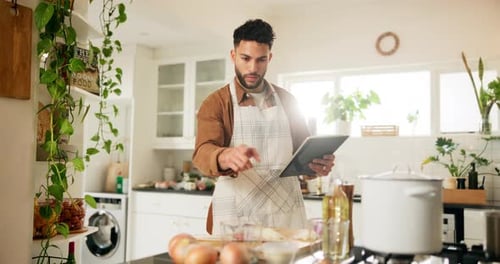Man in Kitchen Cooking with Tablet