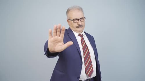 Man in Suit Holds Hand Up to Stop