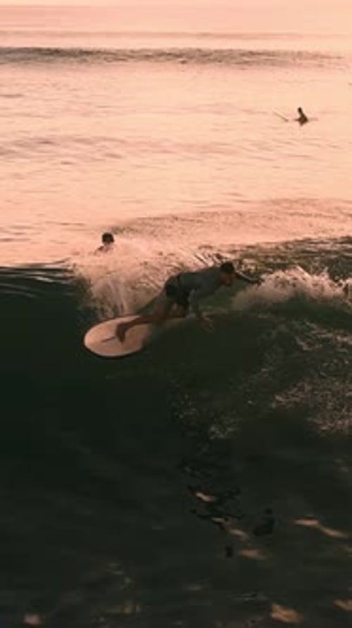 Surfer Riding Wave at Sunset in Vertical Video