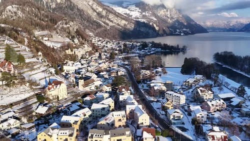 Panoramic drone view of Weesen, Switzerland, in winter. Snowy roofs, the historic church