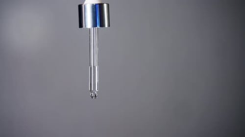 Close Up of Transparent Liquid Dropping from Glass Dropper