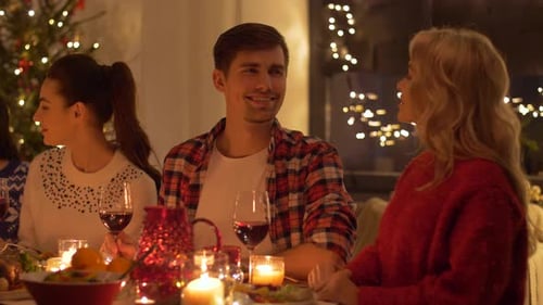 Friends Celebrate Christmas Gathering with Wine and Conversation