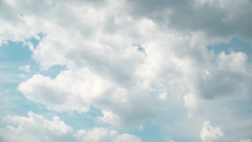 Billowing White Clouds Drifting Across the Blue Sky