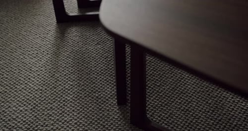 CloseUp of Wooden Table Leg on Textured Carpet with Minimalist Design