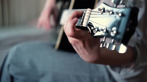 Person Playing Acoustic Guitar Close Up