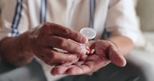 Senior Hands Pouring Pills From Container