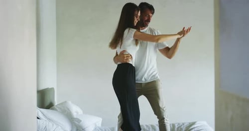 Couple Dancing and Jumping on Bed Together