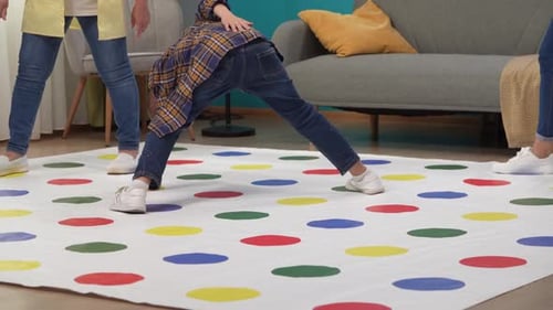 Close Up of Room Big Twister Game on the Floor Boy Grandma and Mother Playing Together Stepping on