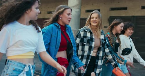 Des amies heureuses se promènent dans la rue et parlent de potins