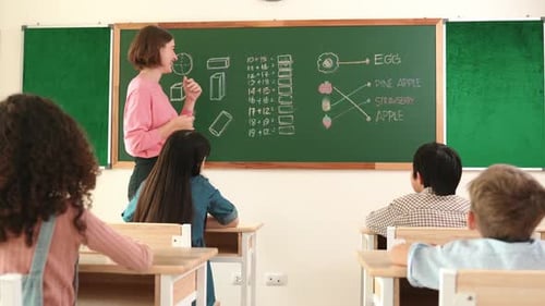Teacher Explaining Math Problems to Students at Chalkboard