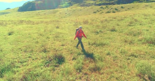 Flight Over Backpack Hiking Tourist Walking Across Green Mountain Field Huge Rural Valley at Summer