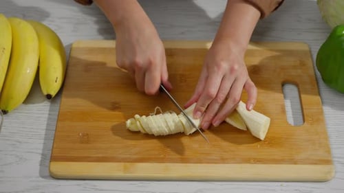 Slicing bananas for a fresh fruit salad preparation