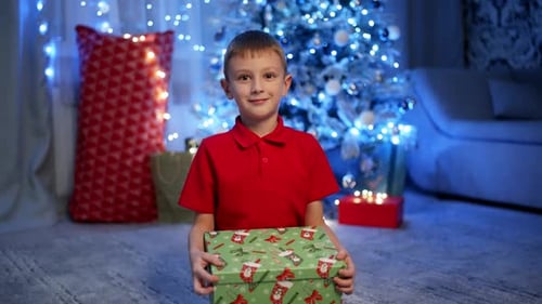 Excited Boy Opening Christmas Gift at Home