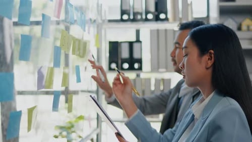 Team Brainstorms on Project with Sticky Notes