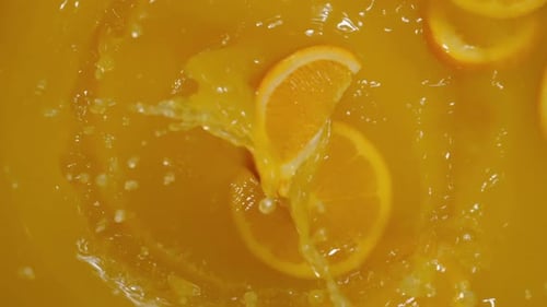 Refrescante cóctel de frutas cítricas con salpicaduras de agua y cubitos de hielo en primer plano