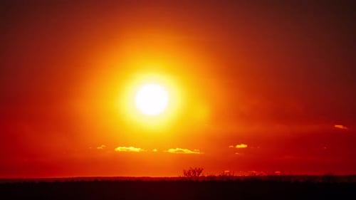 Chronologie d'un coucher de soleil Théâtral avec des rayons de soleil dans le ciel à travers des nuages oranges