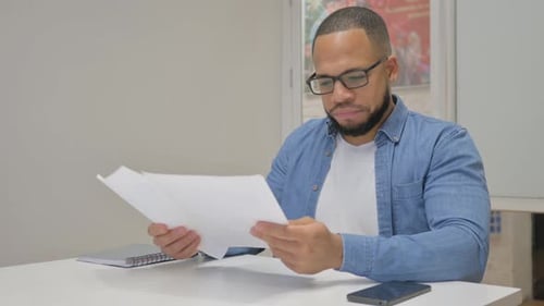 Stressed Man Reviews Charts at Desk
