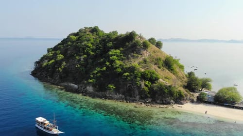 small Pulau Kelor island in Komodo Park, Indonesia, shot from a drone circling around it to showcase
