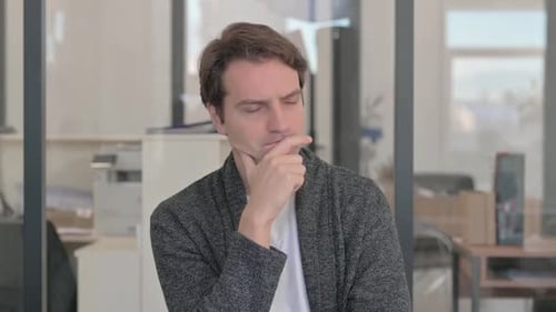 Portrait of Brainstorming Casual Young Man Sitting Thoughtful