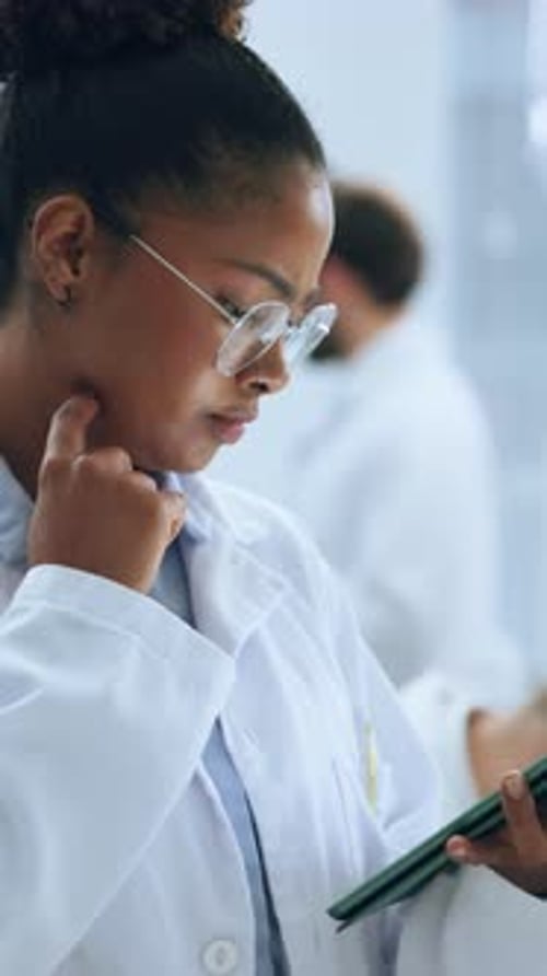 Woman in Lab Coat Using Tablet in Lab