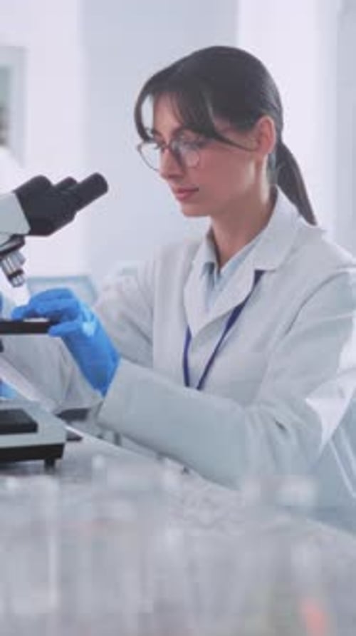 Scientist Working with Microscope in Laboratory Setting